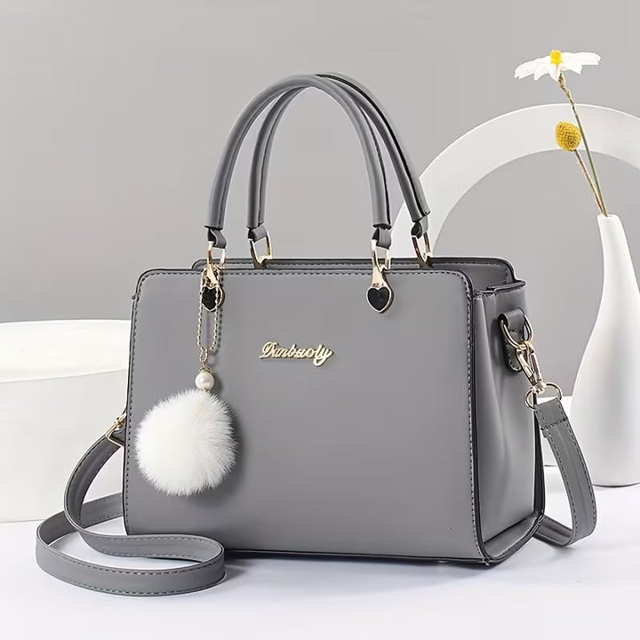 Sanika – Handtasche Mit Pompon Anhänger Und Schulterriemen