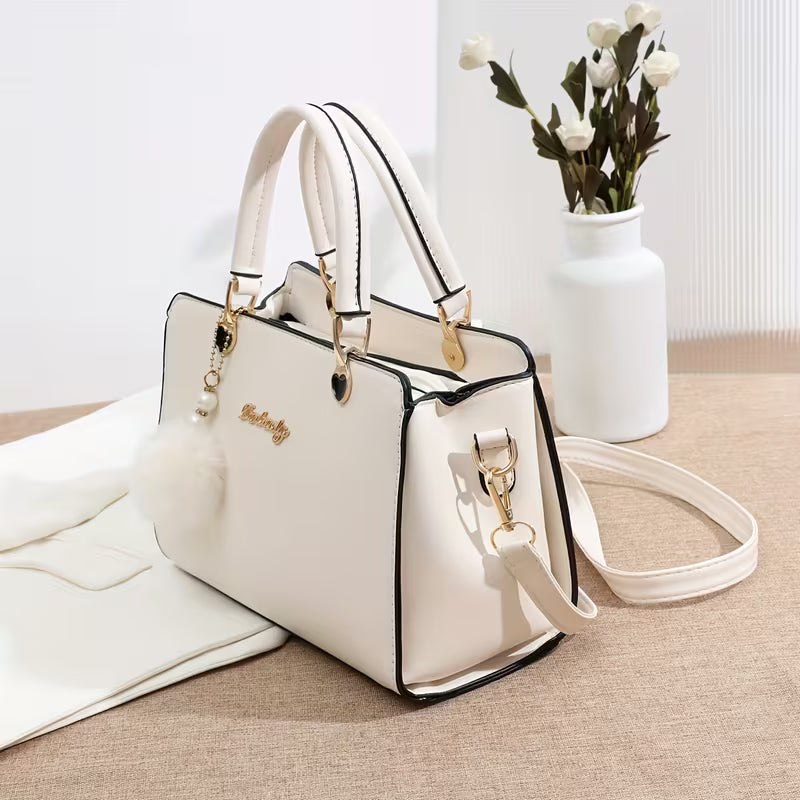 Sanika – Handtasche Mit Pompon Anhänger Und Schulterriemen